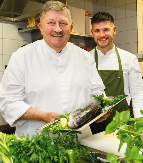Herbert Schmalhofer in der Küche mit Hilfskoch