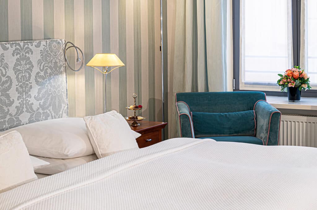 Bett und Sessel in einem Deluxezimmer