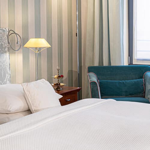 Bett und Sessel in einem Deluxezimmer