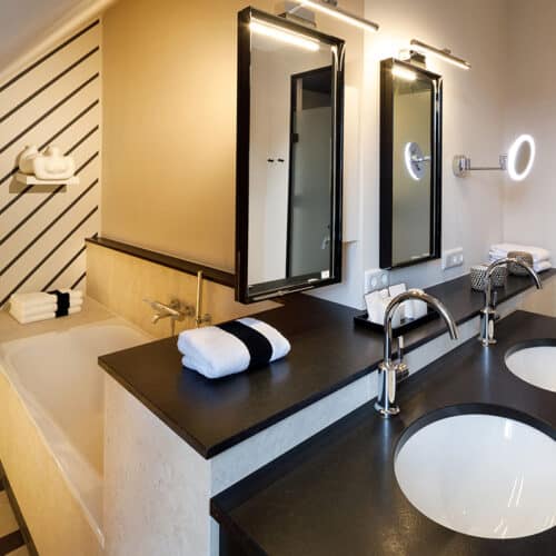Bad mit Badewanne und Doppelwaschbecken in neuer Suite